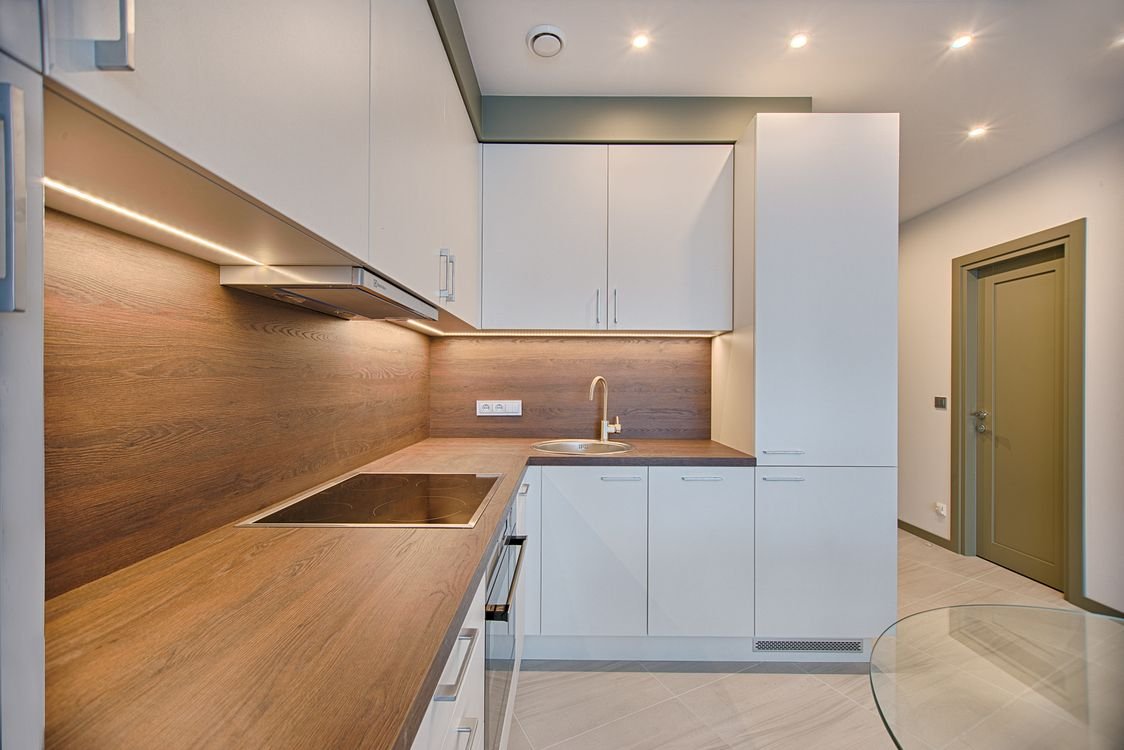 Cocina moderna blanca con acentos de madera y luz natural